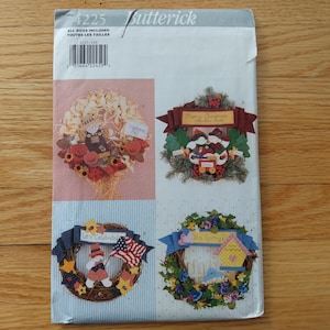 May include: A Butterick pattern envelope displaying four wreath designs. The wreaths are decorated with seasonal and holiday themes, including autumn, Christmas, and patriotic motifs. The envelope has a barcode and the number 4225.