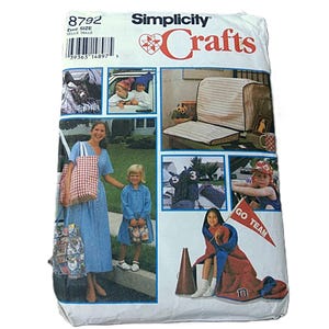 May include: A Simplicity Crafts pattern packet featuring various sewing projects. The package includes images of finished items like seat covers, blankets, and tote bags. The text "Simplicity Crafts" and the pattern number 8792 are visible.