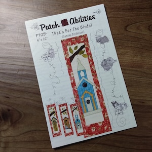 May include: A paper craft pattern titled "That's For The Birds!" featuring a birdhouse design. The pattern includes a central birdhouse illustration in blue and gold, with additional birdhouse motifs below. The dimensions are 6" x 22".