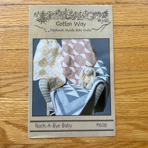 May include: A rectangular paper pattern envelope titled Cotton Way Patchwork Chenille Baby Quilts and Rock-A-Bye Baby #808. The cover features a photograph of three quilted blankets in yellow, pink, and blue patterns draped over a chair.
