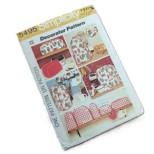 May include: Simplicity 6495 Decorator Pattern. The pattern features images of kitchen accessories with a rooster and leaf design. The pattern includes images of a toaster cover, a bread box cover, and other kitchen items. The pattern is in a white and yellow package.