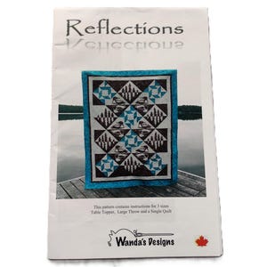 May include: A pattern titled "Reflections" showing a quilt design with geometric shapes in black, white, and teal. The pattern includes instructions for table toppers, large throws, and single quilts. The designer's name, "Wanda's Designs," is also visible.