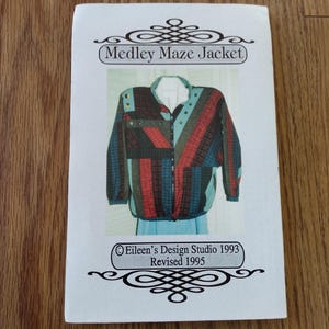 May include: A sewing pattern booklet titled Medley Maze Jacket by Eileen's Design Studio 1993, Revised 1995. The cover features a photograph of a jacket with a multi-coloured, diagonal striped pattern in shades of red, blue, green, and black.