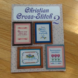 May include: A pattern booklet titled Christian Cross-Stitch 2 featuring four framed cross-stitch designs. The designs include text such as Honor your father and your mother, Love your neighbour as yourself, Love one another, and Love is patient, love is kind.