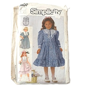 May include: Simplicity sewing pattern 1407. The pattern features a blue floral dress with a white lace collar and cuffs. The package shows illustrations of the dress and other variations. The pattern is for children's clothing.