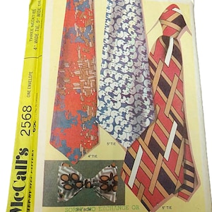 May include: Vintage McCall's pattern envelope featuring illustrations of neckties and a bow tie. The ties have various patterns, including geometric and abstract designs. The envelope is yellow and has text indicating the pattern number, tie widths, and the phrase "One Envelope."