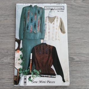 May include: A vintage sewing pattern titled "Pathways & Crossings" featuring three different garment designs. The designs include a teal green suit with a patterned vest, a white vest with a tan undershirt, and a brown jacket with black sleeves. The text "Sew Mini Pieces" is visible.
