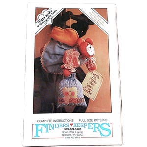 May include: A sewing pattern envelope for a 23 cm Tooth Beary Memorymaker Faerie. The cover features a stuffed bear with orange wings, a blue striped apron, and a small blue polka-dot pouch. Text includes Finders Keepers and pattern details.