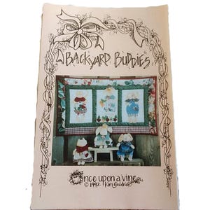 May include: A craft pattern booklet titled BACKYARD BUDDIES with a decorative vine border. The cover features a photograph of a wall hanging and three stuffed animal figures. The bottom text reads Once upon a vine 1992 Kim Goodrich.