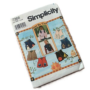 May include: A Simplicity sewing pattern envelope, number 7366, size BB 5, 6, 6X. The front features the text Just Be 'Cuz and illustrations of various sleeveless vests with seasonal appliques like pumpkins, snowmen, and eggs on a light blue background.