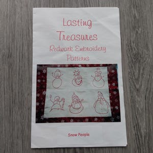 May include: A white paper document titled Lasting Treasures Redwork Embroidery Patterns with a central image of six red-ink snowman illustrations on a light background, framed by a dark red border with white snowflakes and the text Snow People.