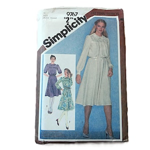 May include: Vintage Simplicity sewing pattern featuring three dress designs. The cover shows a woman in a long-sleeved dress with a cinched waist. The pattern includes sizes and instructions for creating the dresses.