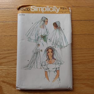 May include: A Simplicity sewing pattern envelope, number 9826, featuring illustrations of four different bridal veil styles. The white paper envelope displays line drawings of veils with various lengths and headpieces, labelled with numbers one through four.