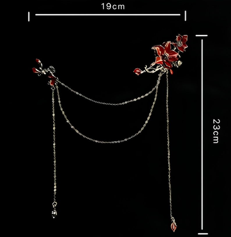 May include: A decorative hair accessory featuring red floral accents and dangling chains. The piece is 19 cm wide and 23 cm long. The design includes silver-toned chains and red flower details, set against a black background.