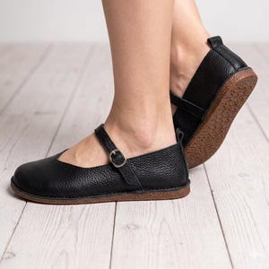 Zapatos planos de piel estilo Mary Jane, cómodos y minimalistas, con puntera ancha y caída cero, confeccionados en piel de vacuno suave de grano superior.