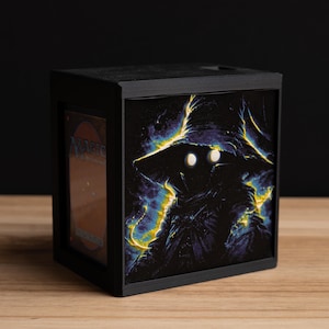 May include: A white ceramic mug with a black handle and the text "But First, Coffee" in a black, handwritten-style font. The mug is on a white surface.