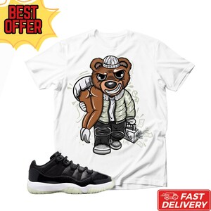 Maglietta unisex Big Bank Bear abbinata alle Jordan 11 Retro Low 72-10, maglietta da abbinare alle sneaker nere e bianche, maglietta streetwear con grafica Money Bear