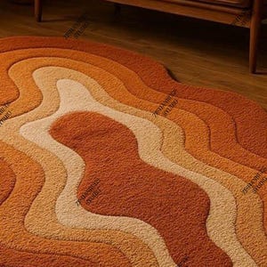 May include: A retro-style rug featuring a layered, wavy design in shades of orange, tan, and cream. The rug's textured surface and warm colours create a cosy atmosphere. The rug is placed on a wooden floor, with a glimpse of a wooden sofa in the background.