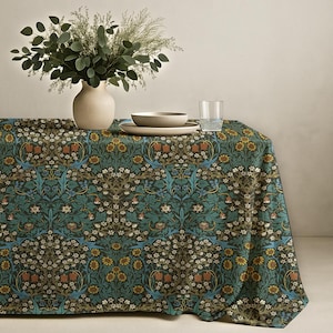 May include: A rectangular tablecloth featuring a dense, repeating botanical pattern in shades of teal, mustard yellow, brown, and white. The design includes stylized flowers, leaves, and vines covering the entire surface of the fabric.