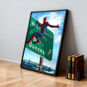 May include: Framed poster featuring Spider-Man in a red and blue suit, posed on a green highway sign pointing towards Brooklyn, Bronx, and Queens. The poster has a black frame and a cityscape in the background. The words "COMING SOON" are at the bottom.