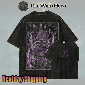 May include: Black t-shirts with a faded wash effect. The larger shirt features a purple and white graphic of a monster with the text "The Wild Hunt." The smaller shirt has a circular purple design. The top left corner has a logo.