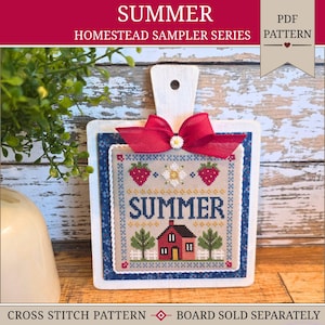 May include: A decorative wooden cutting board with a cross-stitch design. The cross-stitch features the word "SUMMER", strawberries, a house, and trees. A red bow with a daisy adorns the top. The text "HOMESTEAD SAMPLER SERIES" is above the design.