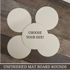 Puede incluir: Cinco círculos de cartón sin terminar, de color blanquecino, sobre una superficie de madera. El círculo central tiene el texto "CHOOSE YOUR SIZE!". La parte inferior de la imagen dice "UNFINISHED MAT BOARD ROUNDS".