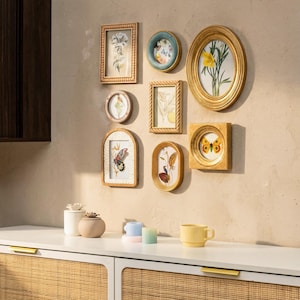Könnte beinhalten: Eine Sammlung gerahmter botanischer Kunstwerke in verschiedenen Formen und Größen, darunter rechteckige, ovale und kreisförmige Rahmen. Die Rahmen sind in Gold- und Naturholztönen gehalten und zeigen Bilder von Blumen, Schmetterlingen und anderen Naturelementen.