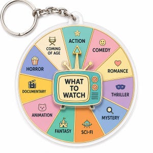 May include: A circular keychain featuring a colorful decision wheel with ten movie genres including Action, Comedy, Romance, Thriller, Mystery, Sci-Fi, Fantasy, Animation, Documentary, and Horror, centered by a teal television icon labeled What To Watch.