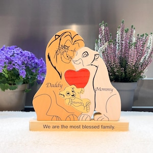 May include: Wooden family figurine featuring a lion family with the words "Daddy", "Mommy", and "Murray". The figurine has a red heart in the center and the text "We are the most blessed family."