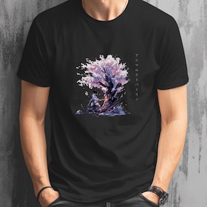 Könnte beinhalten: Schwarzes T-Shirt mit einer Aquarellillustration eines Baumes mit rosa Blüten und zwei Figuren. Japanischer Text ist vertikal auf der rechten Seite des Designs aufgedruckt. Das Kunstwerk ist vor einem dunklen Hintergrund.