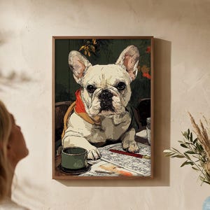 Könnte beinhalten: Ein gerahmtes Kunstwerk zeigt eine französische Bulldogge an einem Schreibtisch mit rotem Halsband. Der Hund ist von Papieren und einer grünen Tasse umgeben. Das Kunstwerk wird an einer beigen Wand über einem Holzschrank mit Lampe und Vase ausgestellt.