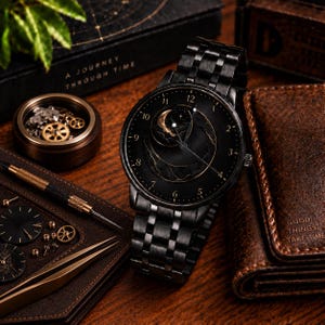 Peut inclure: Une montre-bracelet en métal noir avec un cadran sombre orné d'un motif de croissant de lune et d'étoiles dorées. La montre possède un bracelet à maillons noir assorti, des aiguilles fines et des chiffres pour les heures.
