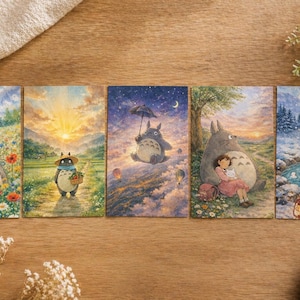 May include: Five illustrated postcards featuring scenes with Totoro characters. The cards depict Totoro in various settings: a field of flowers, a sunset, under a starry sky, with a girl, and in a snowy hot spring. The illustrations have a watercolor style.