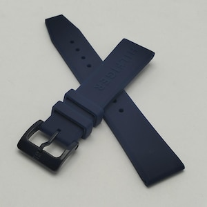 May include: Navy blue watch strap with a black buckle. The strap is made of a flexible material and features the brand name "HILFIGER" embossed on one of the straps.