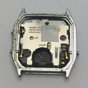 May include: A silver-toned watch case with the internal components visible. The watch face includes the text "CASIO JAPAN NO(0)JEWELS UNADJUST". The internal components are silver and gold-toned, with a black battery compartment.