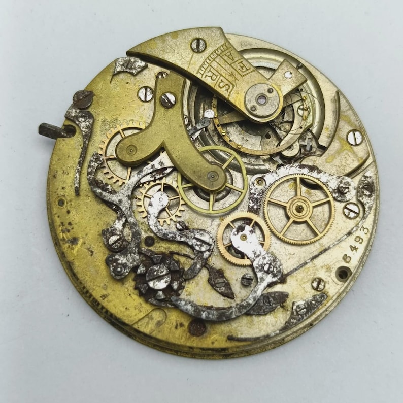 May include: Close-up of a vintage watch movement with intricate gears, springs, and levers. The metal components are in shades of gold and silver, showing signs of age and wear. The number "6493" is visible.