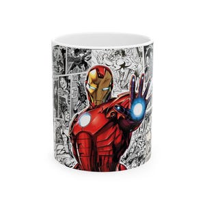 May include: A white ceramic mug featuring a colourful illustration of Iron Man in a red and gold suit with a glowing blue repulsor blast on one hand and a chest arc reactor. The background is a black and white comic book panel collage.