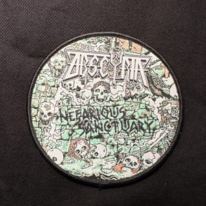 May include: Round patch with the word "ABSCYTH" in a gothic font above the words "NEFARIOUS SANCTUARY". The patch features a green and white design with skulls and other imagery, set against a black background.
