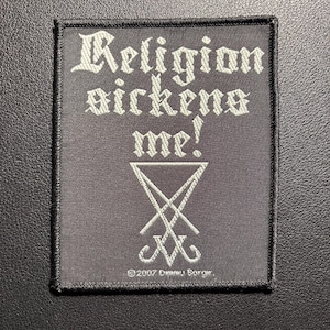Könnte beinhalten: Ein schwarzer quadratischer Aufnäher mit dem Schriftzug "Religion sickens me!" in weißer gotischer Schrift. Darunter befindet sich ein weißes umgekehrtes Kreuzsymbol. Der Aufnäher ist mit schwarzen Nähten eingefasst.