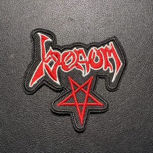 Op de afbeelding: Een zwart embleem met het woord "Venom" in rode, gestileerde letters. Daaronder een rode pentagram. De patch heeft een zwarte rand met witte stiksels.