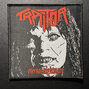 Könnte beinhalten: Schwarzer quadratischer Aufnäher mit dem Wort "TRAITOR" in roten Buchstaben über einem Schwarz-Weiß-Bild eines Gesichts. Die Worte "eternal nightmare" stehen darunter in Rot.