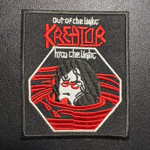 Könnte beinhalten: Schwarzer, gestickter Aufnäher mit dem Bandnamen "Kreator" in Rot, mit dem Text "out of the light" und "into the light". Der Aufnäher zeigt eine Grafik einer Person in einem roten Pool. Der Aufnäher ist quadratisch mit schwarzem Rand.