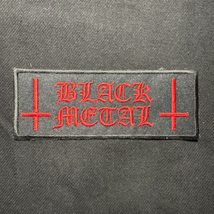 Puede incluir: Un parche rectangular negro con las palabras "BLACK METAL" bordadas en rojo con letras góticas. Dos cruces rojas flanquean el texto. Ideal para personalizar ropa.
