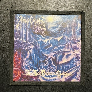 May include: Square patch with a fantasy landscape design in shades of blue, purple, and white. The patch features a mountain range, a castle, and the text "In The Nightside Eclipse" and the band name "Emperor". The patch has a black border.