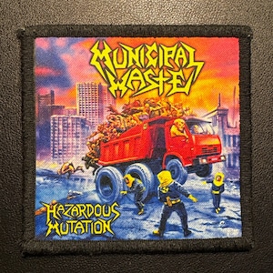 Könnte beinhalten: Gestickter Aufnäher mit einem roten Muldenkipper voller Figuren, mit dem Text "Municipal Waste" in Gelb und "Hazardous Mutation" in Blau. Der Hintergrund zeigt eine Skyline und Figuren in Schutzanzügen.