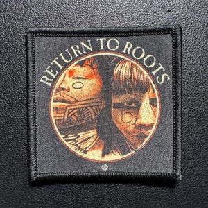 Può includere: Toppa quadrata nera con le parole "RETURN TO ROOTS" in testo bianco arcuato. Il centro presenta un disegno circolare con due volti nei toni dell'arancione e del marrone. La toppa ha un bordo nero.