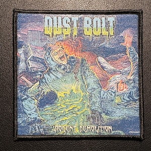 May include: Square patch with a black border featuring the text "DUST BOLT" in yellow and green. The image depicts a person in a hazmat suit engulfed in flames, with the words "VIOLENT DEMOLITION" below.