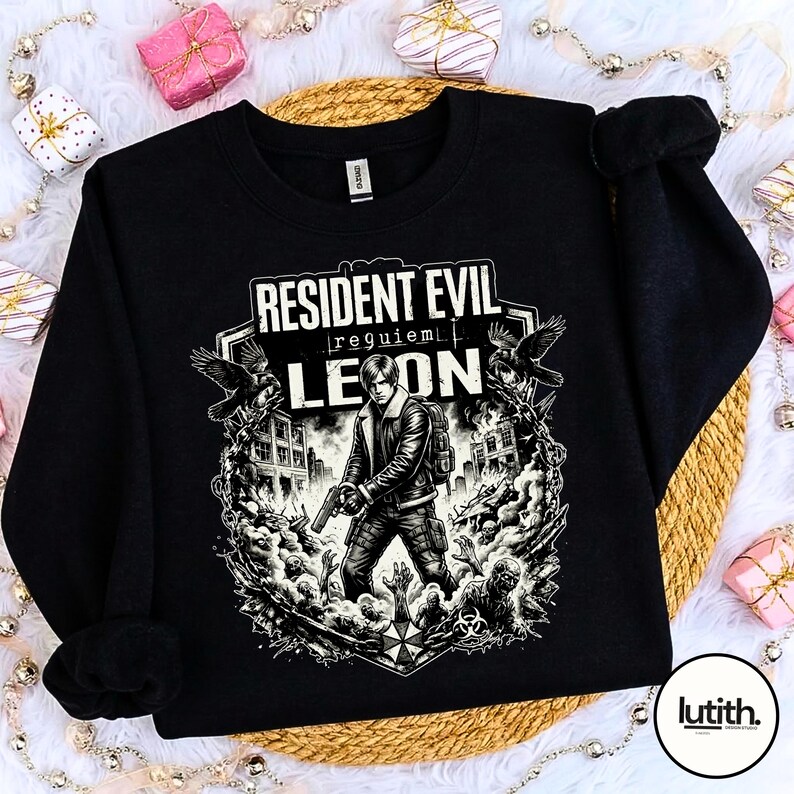 Może przedstawiać: Czarna bluza z grafiką z Resident Evil. Projekt zawiera napis "Resident Evil Requiem Leon" oraz ilustrację postaci trzymającej broń, otoczonej przez zombie i budynki.