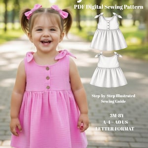 May include: A young child wearing a pink dress with wooden buttons. The dress is sleeveless with tie details on the shoulders. The image includes the text "Pink Joy Dress" and "PDF Digital Sewing Pattern". Also included is a sewing guide.